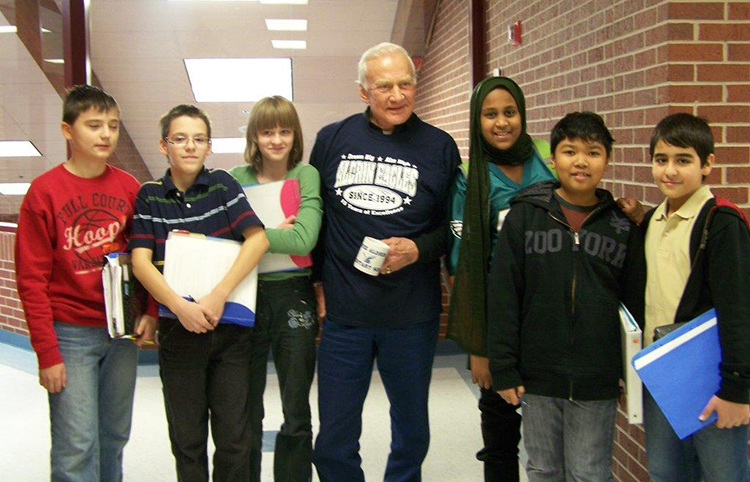 Photograph of Buzz Aldrin standing with a group of nine smiling students.
