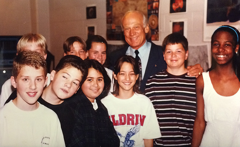 Photograph of Buzz Aldrin standing with a group of nine smiling students.