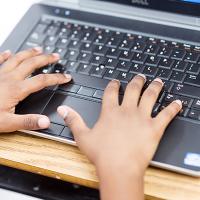 hands typing on a computer