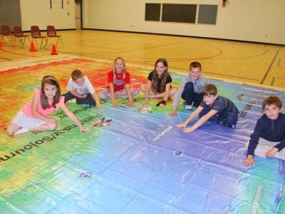 students sitting on floor map of Mars