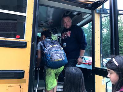 image of Mr. Wolfe principal welcoming students onto their bus after dismissal